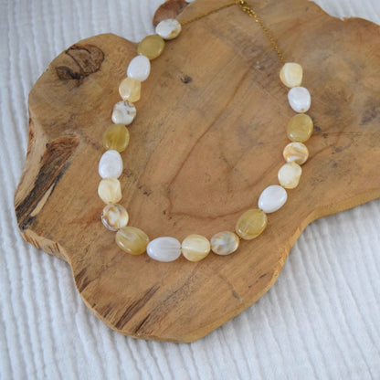 Détail du collier en acier inoxydable doré avec perles beiges et nacrées.