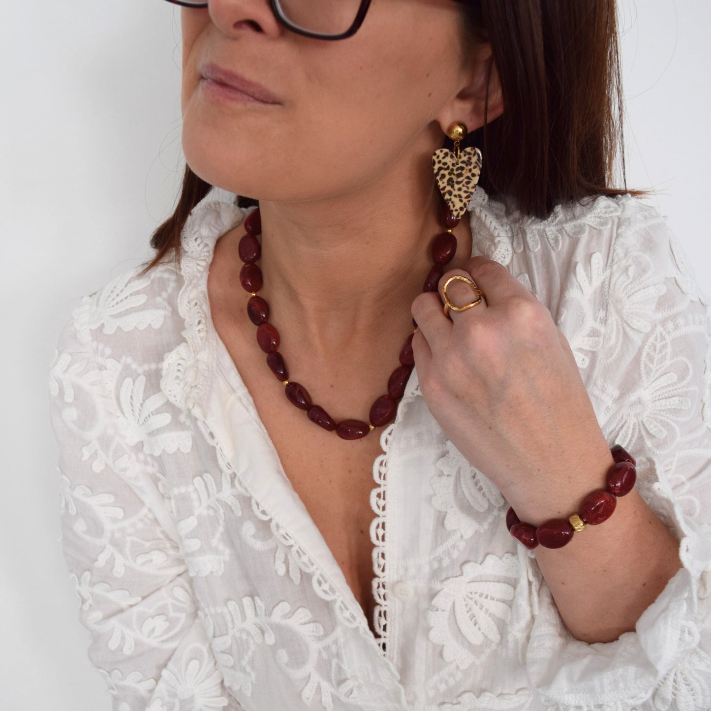 Bijou bordeaux élégant porté sur chemisier blanc