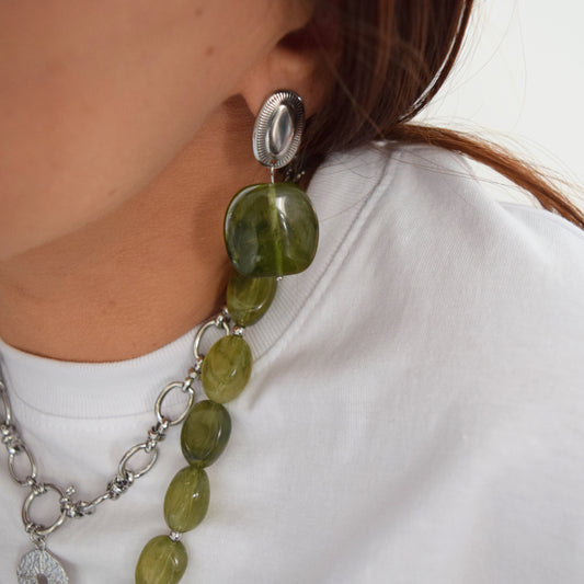 Boucles pendantes vertes portées à l’oreille