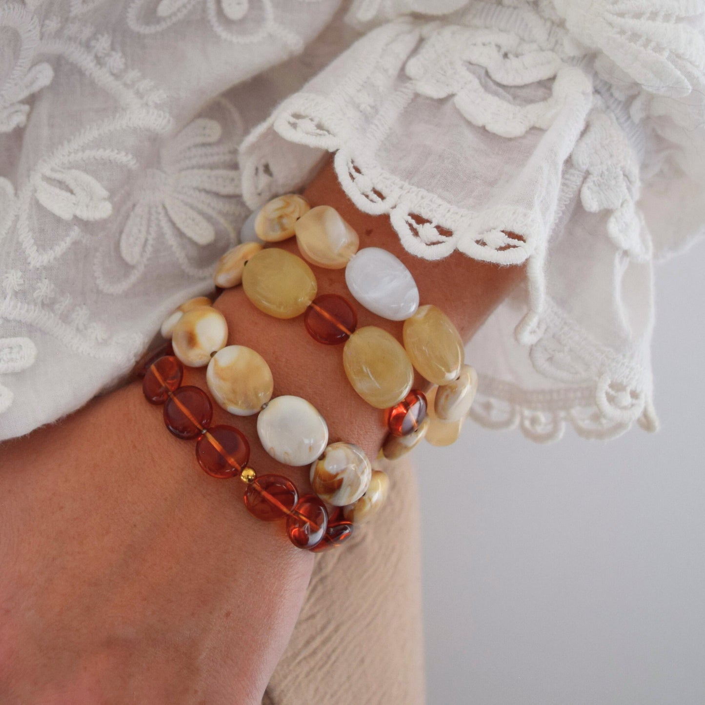 Gros plan sur bracelet femme en perles acryliques tons ambrés, création artisanale Manacreations