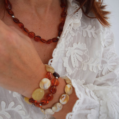 Collier ISOLDE porté sur cou, reflets ambrés et perles dorées montées sur chaîne fine