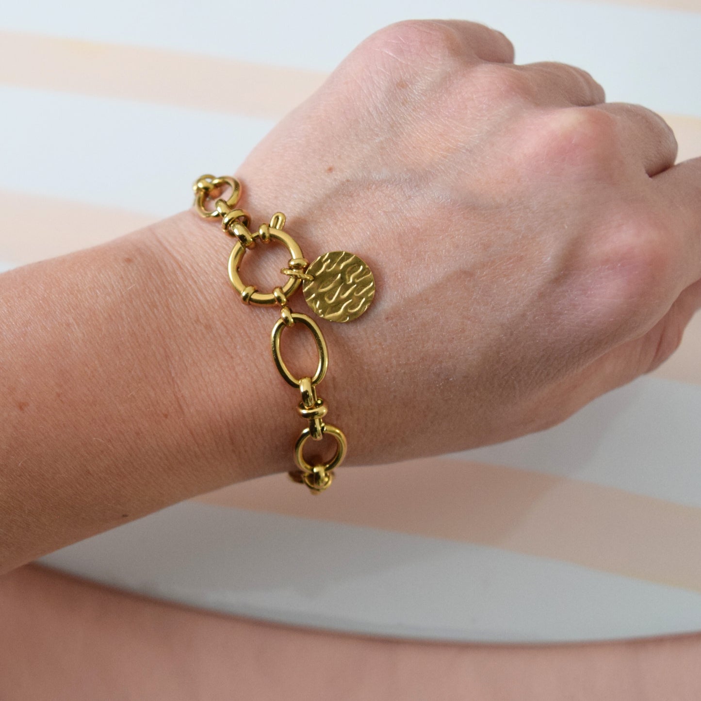 Bracelet chaîne dorée porté au poignet
