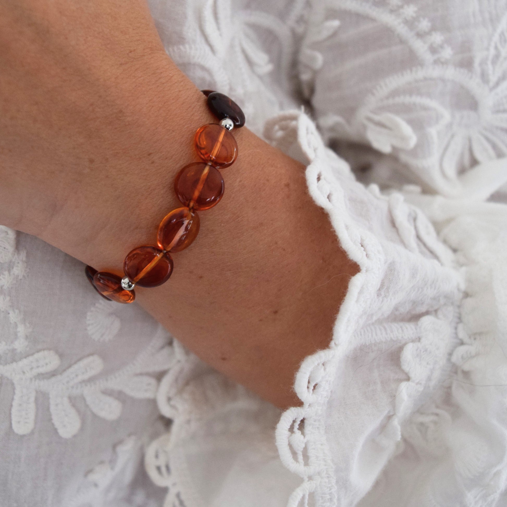 Vue rapprochée d’un bracelet artisanal avec perles ambrées lumineuses