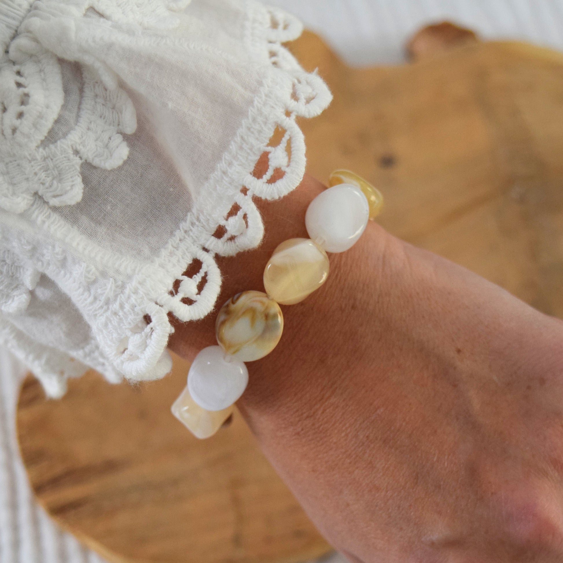 Détail du bracelet en perles ovales blanches et beige, création Manacreations.