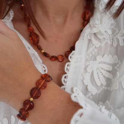 Bracelet lumineux porté, reflets dorés et transparents des perles ambre.