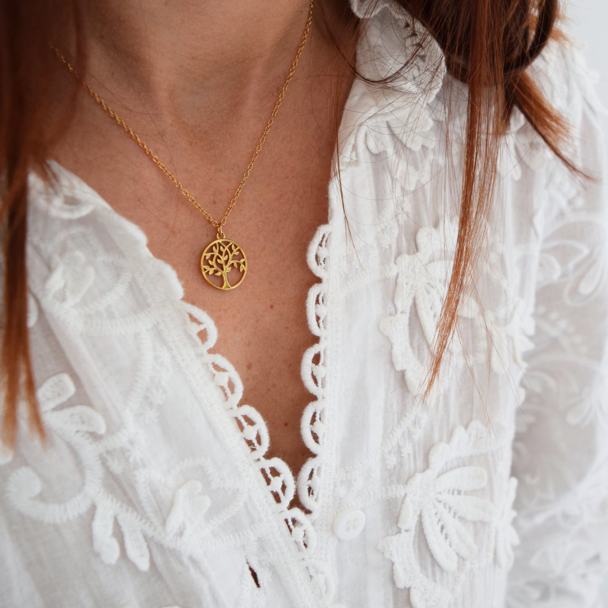 Collier arbre de vie en acier inoxydable doré porté sur chemise blanche