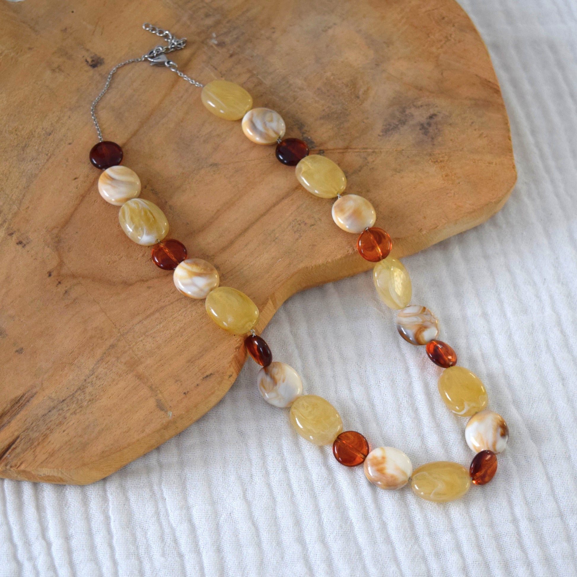 Vue rapprochée du collier artisanal sur fond naturel.