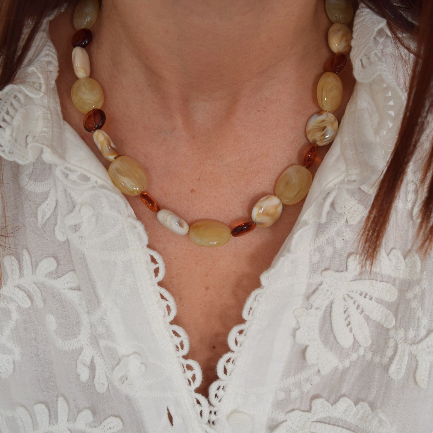 Collier lumineux mis en valeur sur un col brodé.