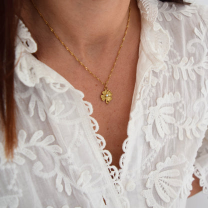 Détail du pendentif trèfle doré à l’or fin avec strass brillant