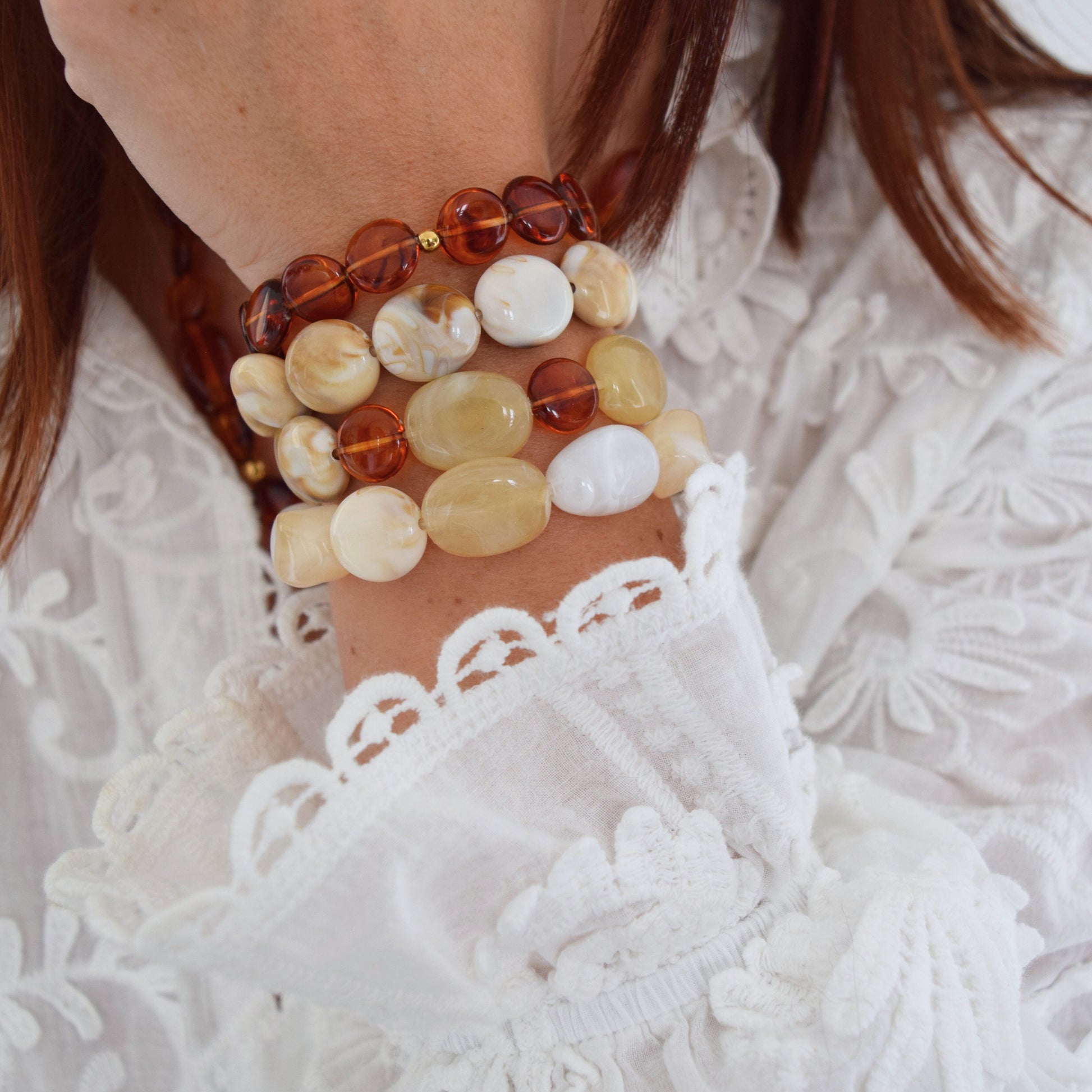 Bracelet perles rondes aux reflets ambrés porté au poignet, bijou élégant et confortable.